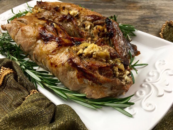 apple stuffed pork tenderloin on a white platter