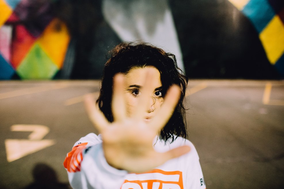 young woman with hand out to say stop