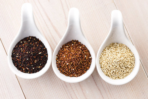 three white ceramic spoons with red, white and black quinoa