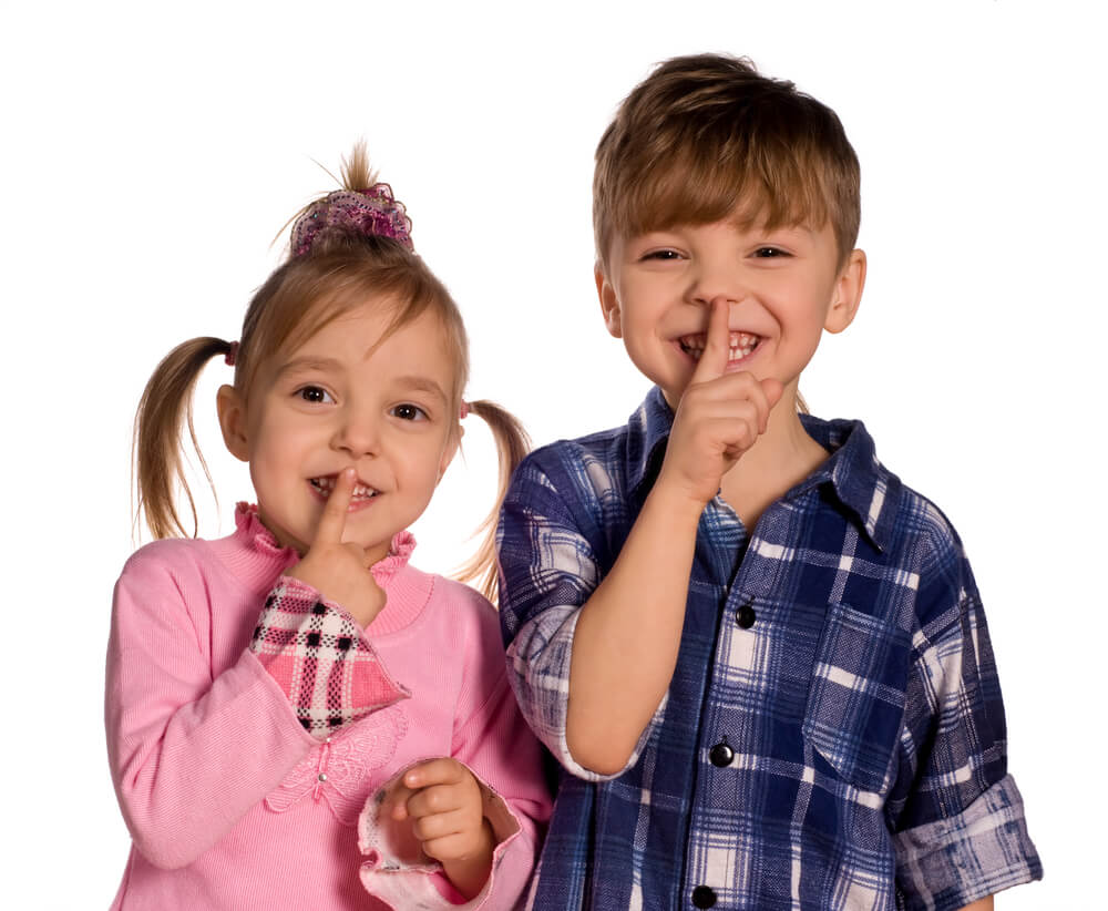 Young child with fingers to lips for quiet